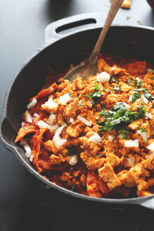 Pan of Vegan Tofu Chilaquiles topped with fresh cilantro and onion