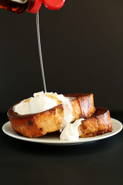 Pouring syrup onto slices of dairy-free Coconut French Toast