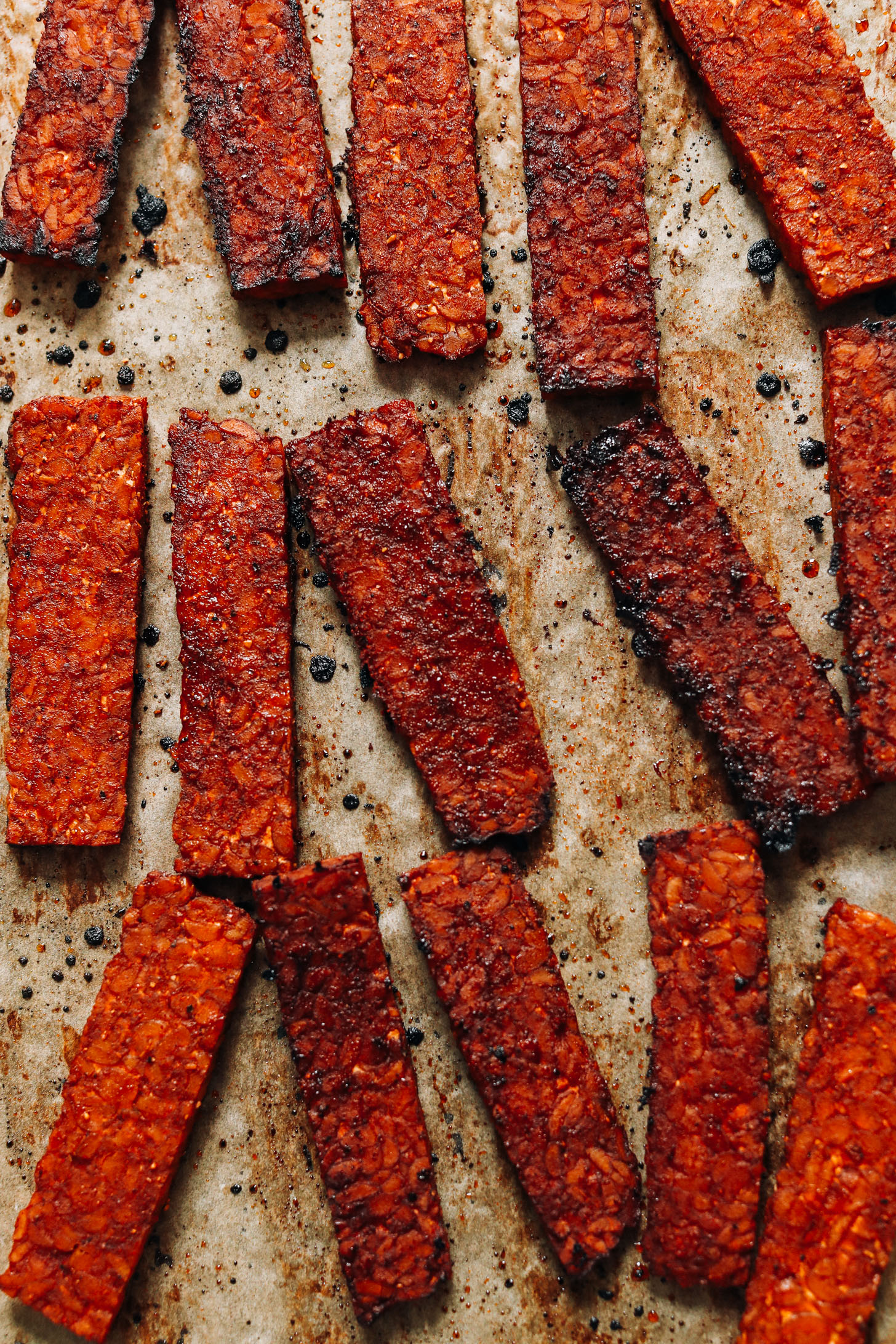 Baked tempeh bacon strips on a baking sheet