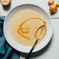 Bowl of Ginger Garlic Miso Tahini Dressing with a swirl of toasted sesame oil