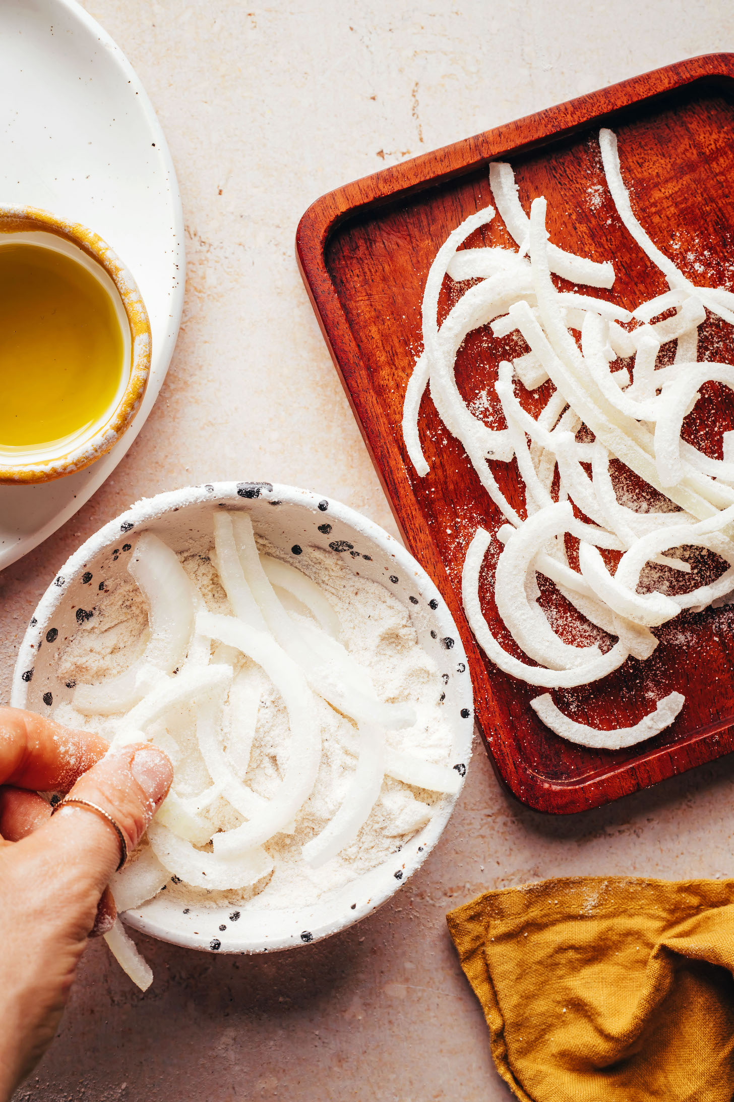 Dipping thinly sliced onions into a flour mixture