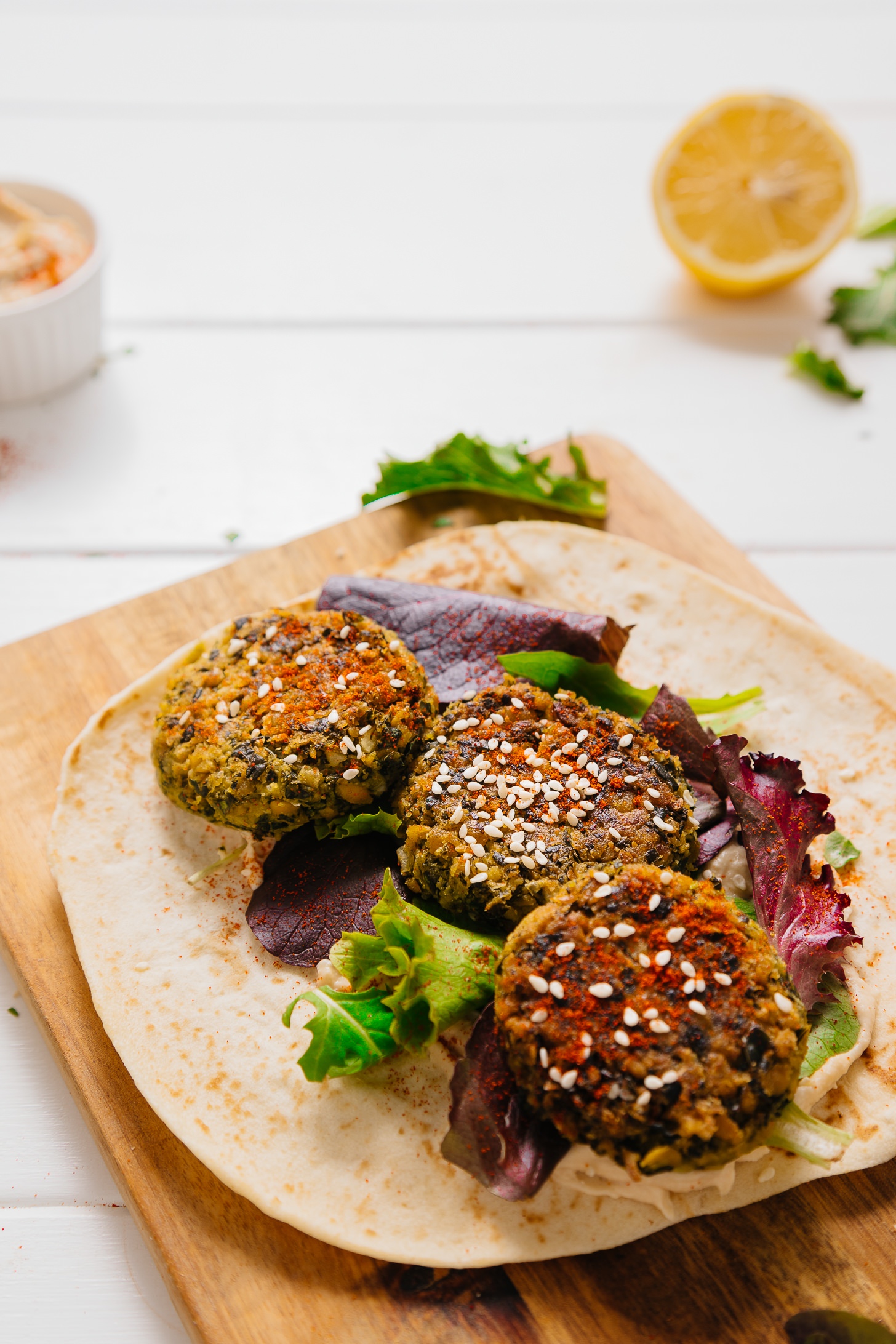 Kale Falafel Hummus Wrap on a wood cutting board