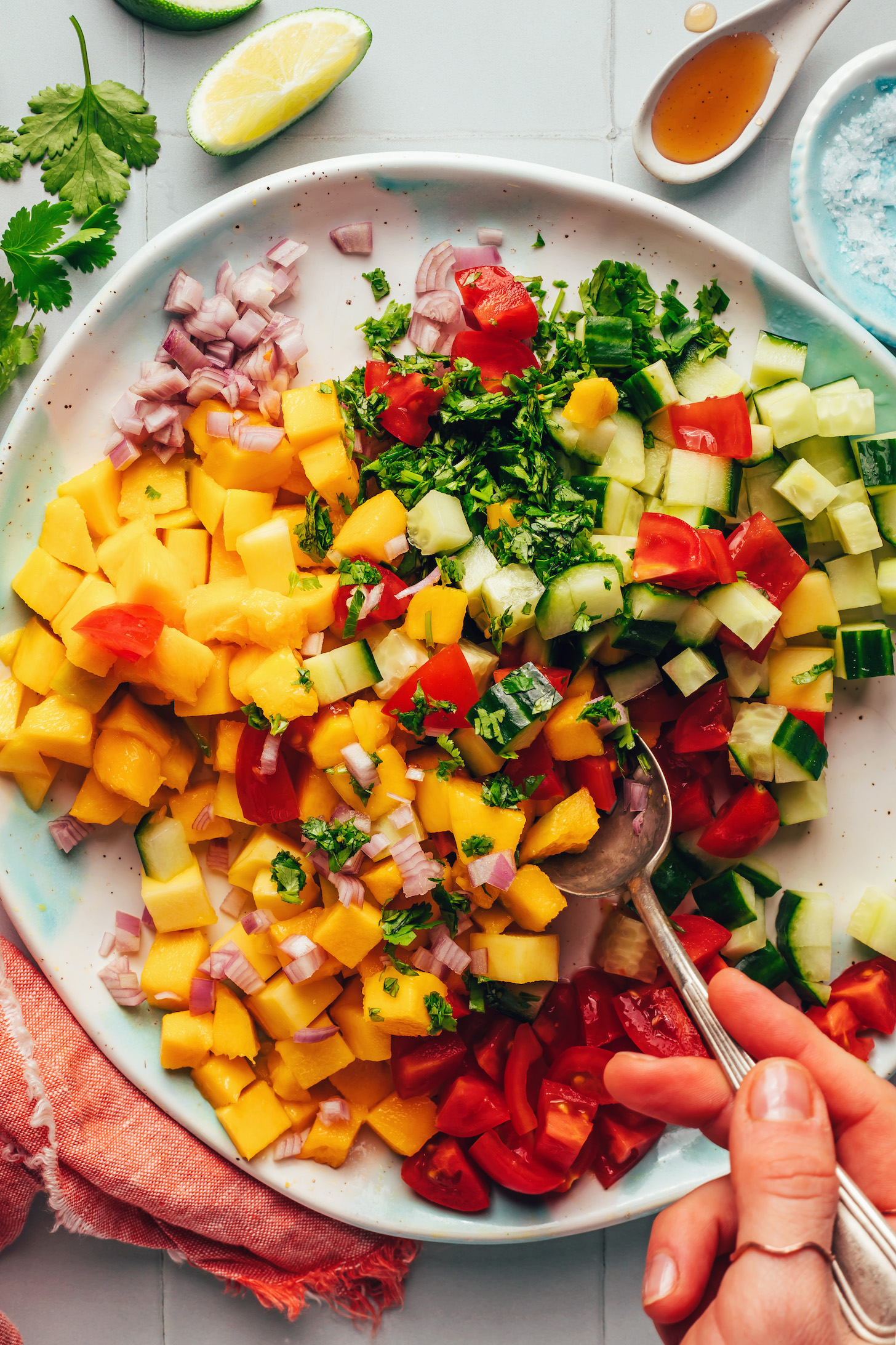 Using a spoon to mix together our Easy Mango Cucumber Salad