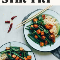 Two plates of our vegan gluten-free Almond Butter Tofu Stir-Fry served with brown rice