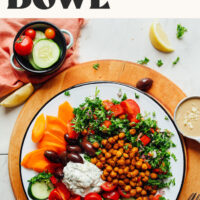 Overhead photo of a bowl our Greek Goddess Bowl recipe with fresh vegetables, crispy chickpeas, and tzatziki