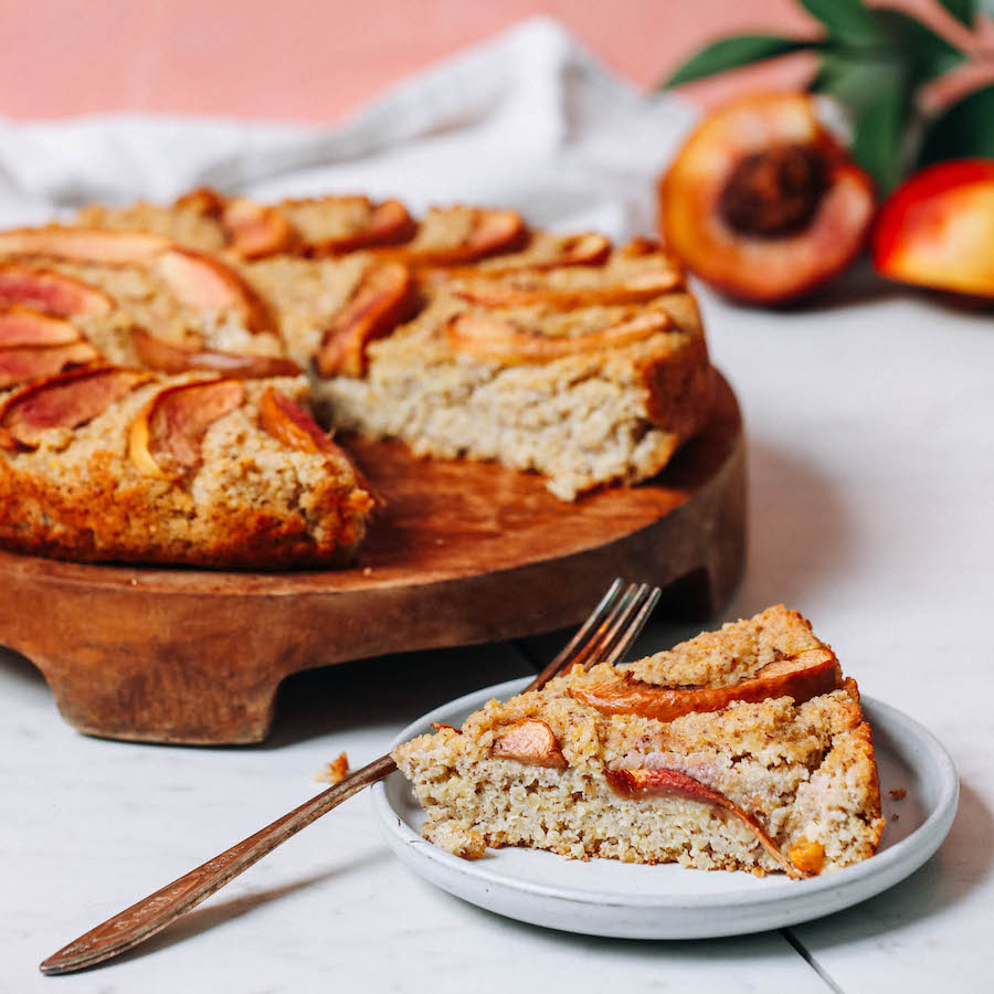 Slice and platter of millet breakfast cake with stone fruit