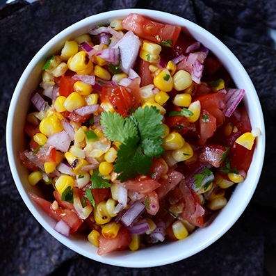 Overhead shot of a big bowl of Grilled Corn Salsa topped with fresh cilantro